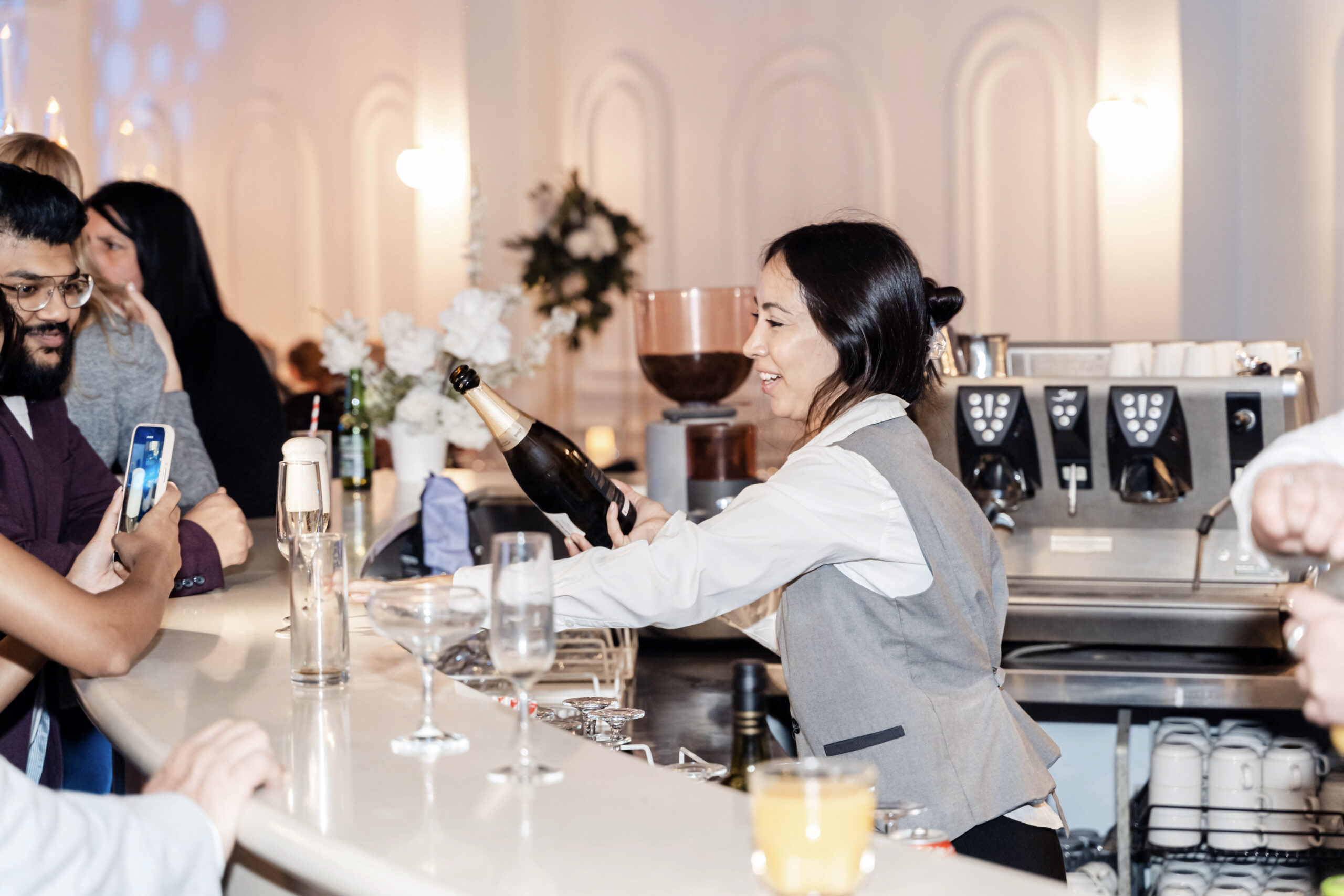 Staff serving champagne in the bar people enjoy and taking photo